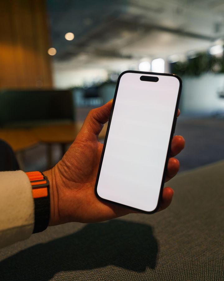办公场景手持手机图，示意 App 核验报告界面